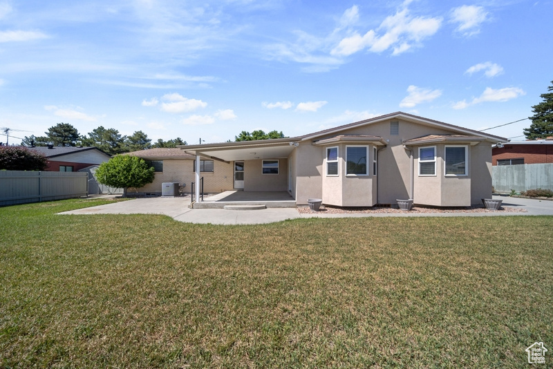 Back of house with a patio, stucco siding, and an attached carport