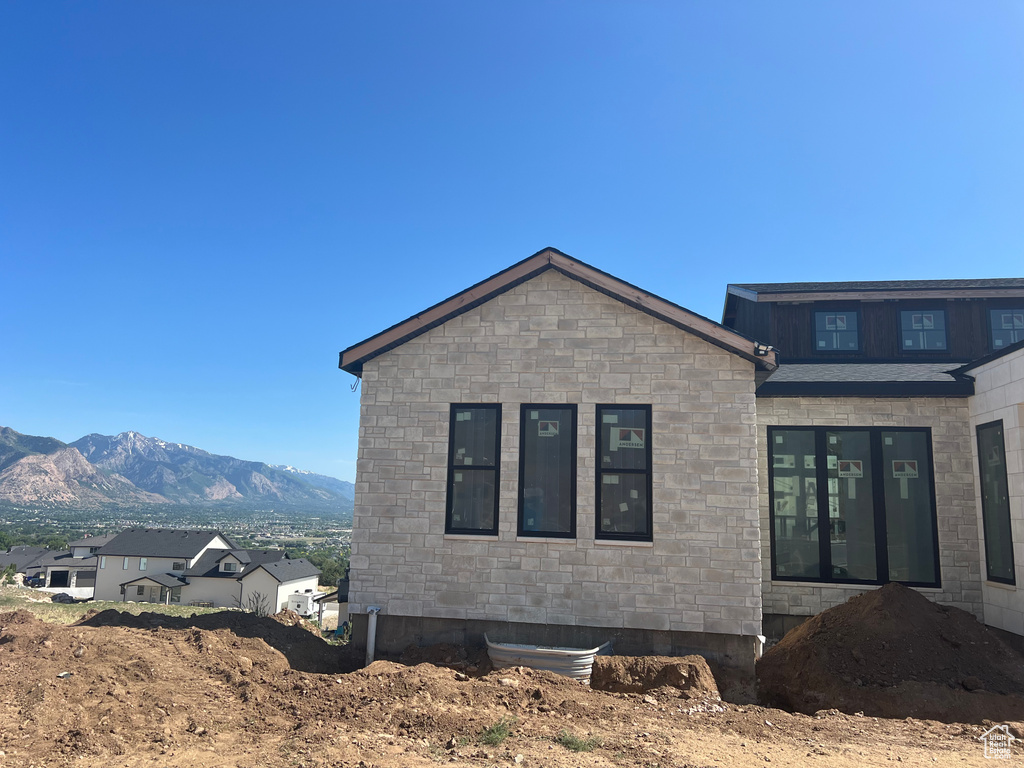View of home's exterior with stone siding and a mountain view