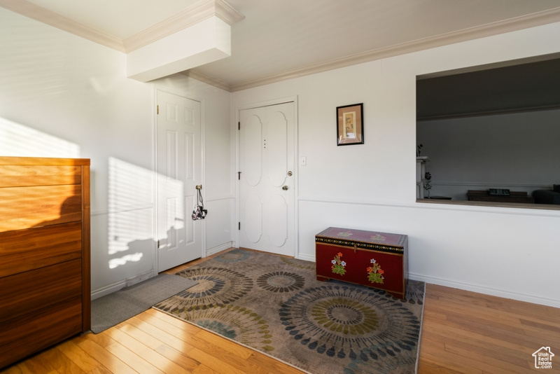 Entrance foyer with wood finished floors and ornamental molding