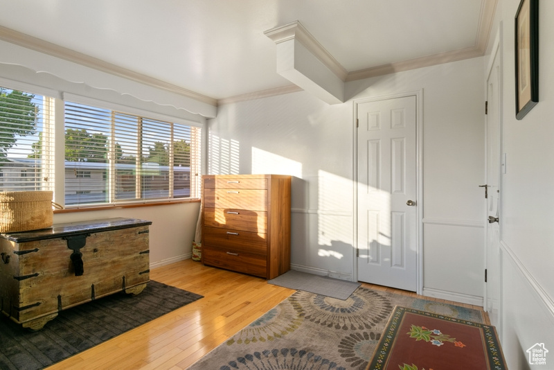 Bedroom with ornamental molding and light wood finished floors