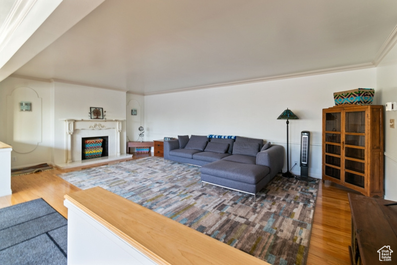 Living area featuring wood finished floors and a warm lit fireplace