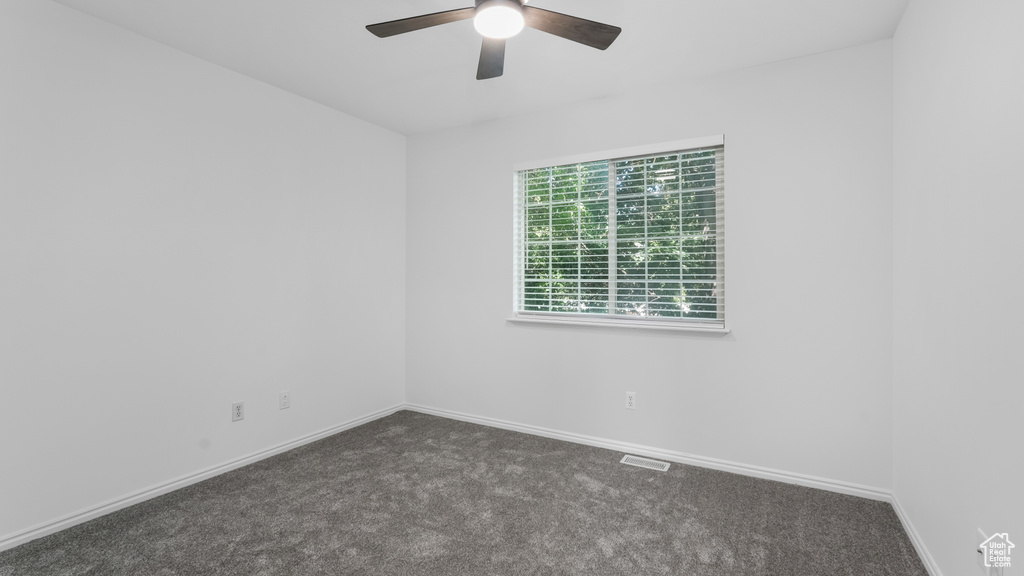 Unfurnished room featuring carpet floors, ceiling fan, and baseboards
