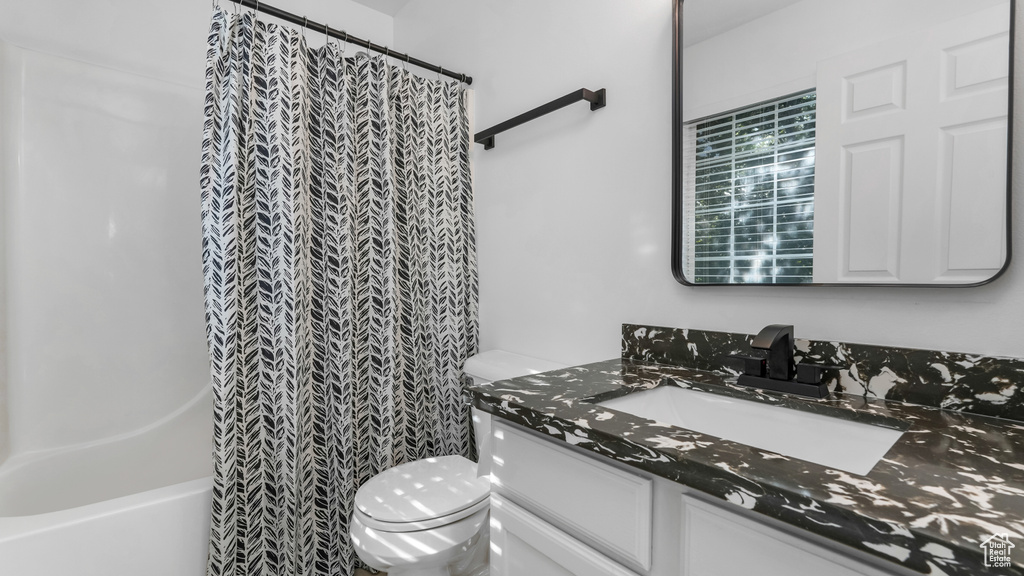 Bathroom featuring vanity, toilet, and shower / tub combo