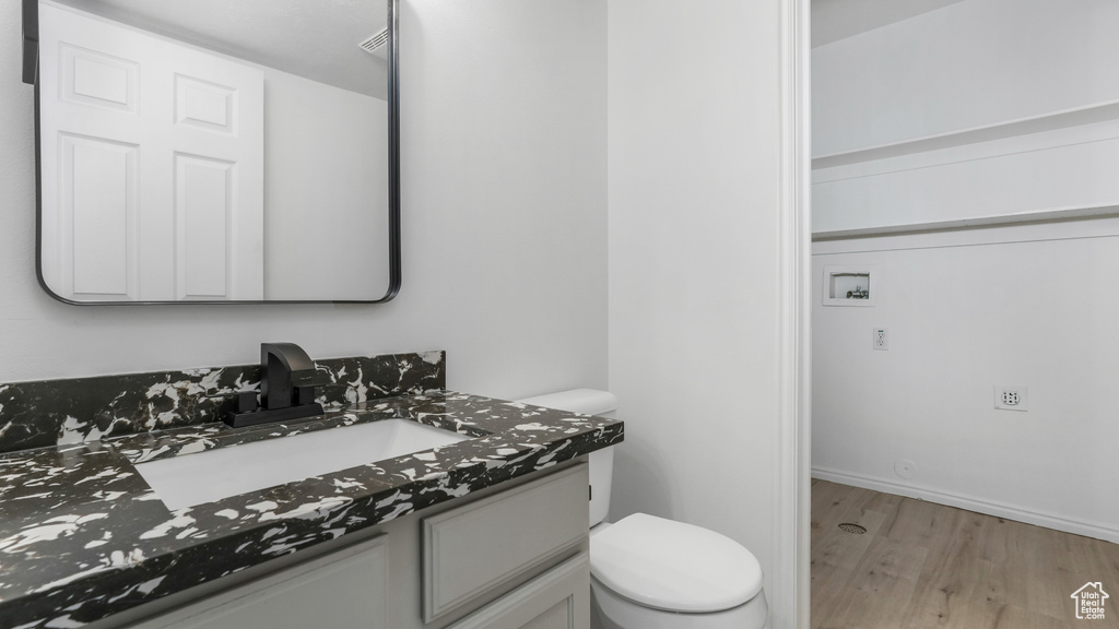 Bathroom with wood finished floors, toilet, and vanity
