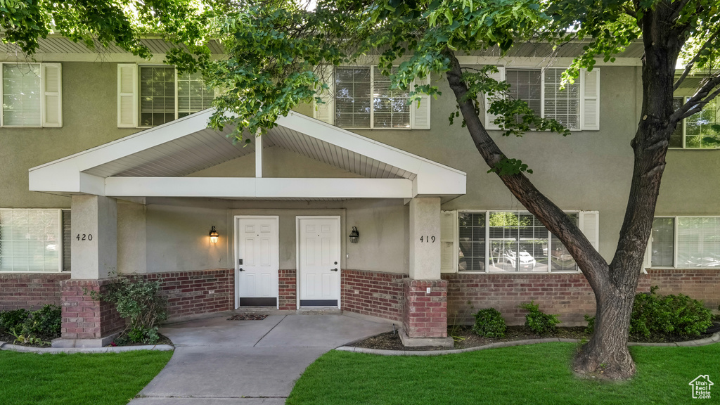 View of front of home featuring brick siding and stucco siding