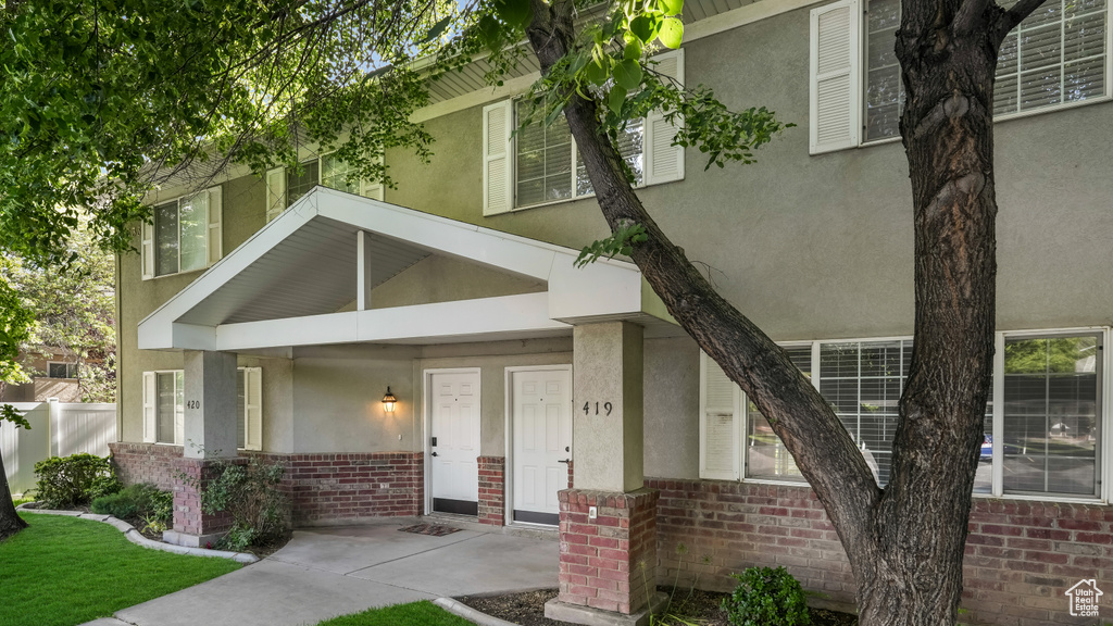 Entrance to property featuring brick siding and stucco siding