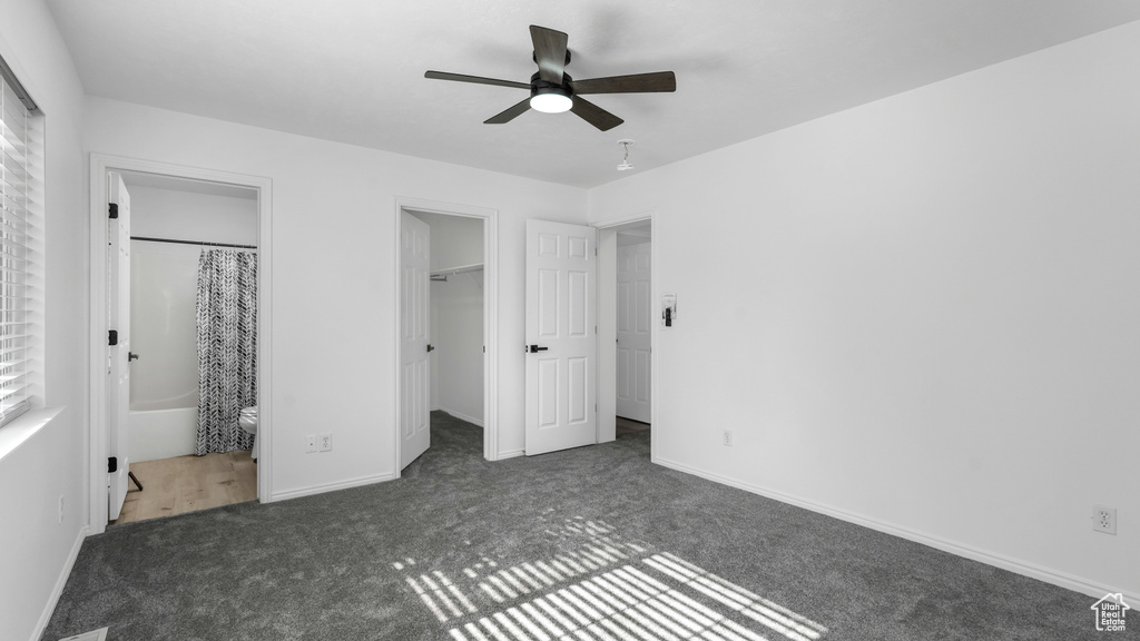 Unfurnished bedroom featuring carpet floors, a spacious closet, baseboards, connected bathroom, and a closet