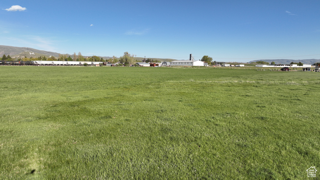 View of green lawn with a mountain view and a rural view