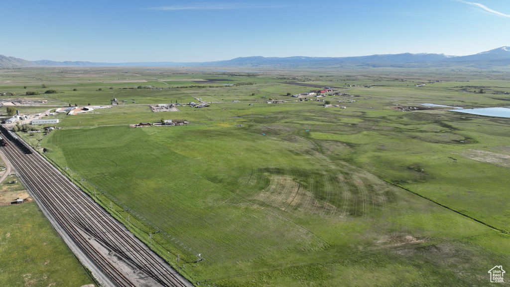 Aerial view of property and surrounding area featuring rural landscape and a water and mountain view