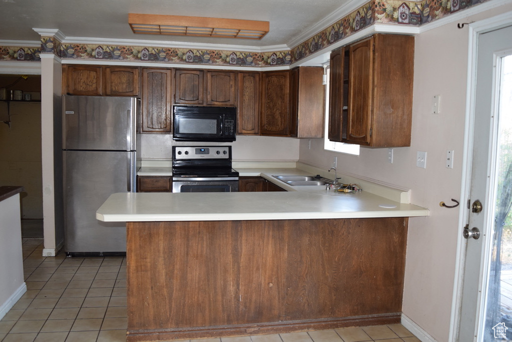 Kitchen with stainless steel appliances, a sink, light tile patterned floors, a peninsula, and light countertops