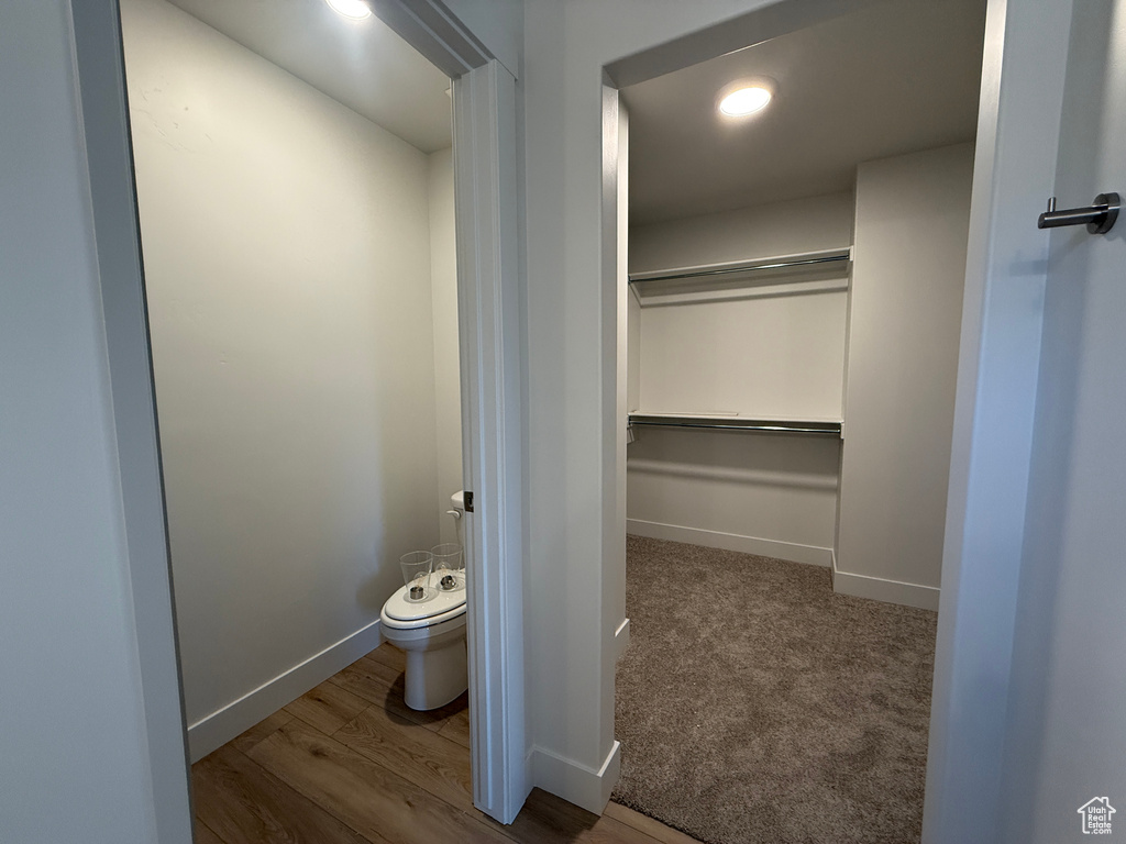 Bathroom featuring toilet, baseboards, and wood finished floors