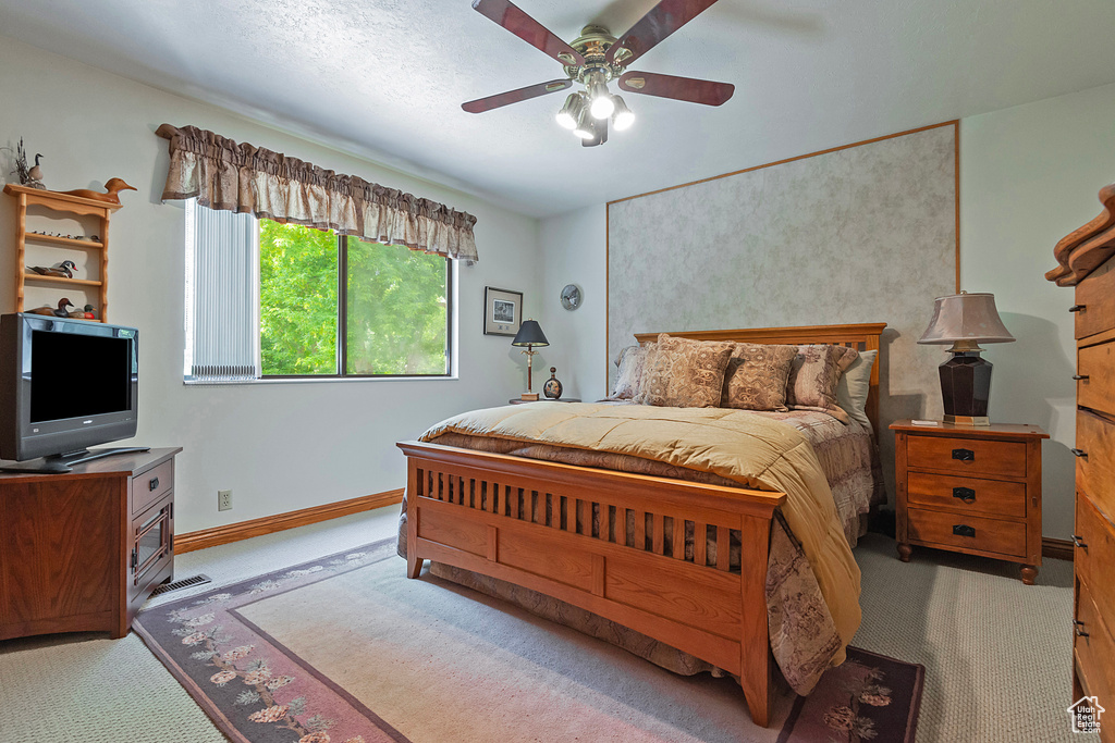 Carpeted bedroom featuring baseboards and ceiling fan