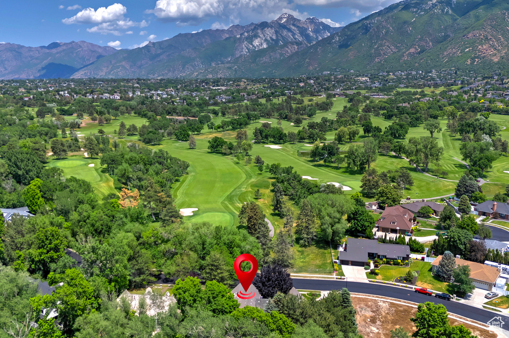 Aerial view of residential area featuring a mountain backdrop and a golf course