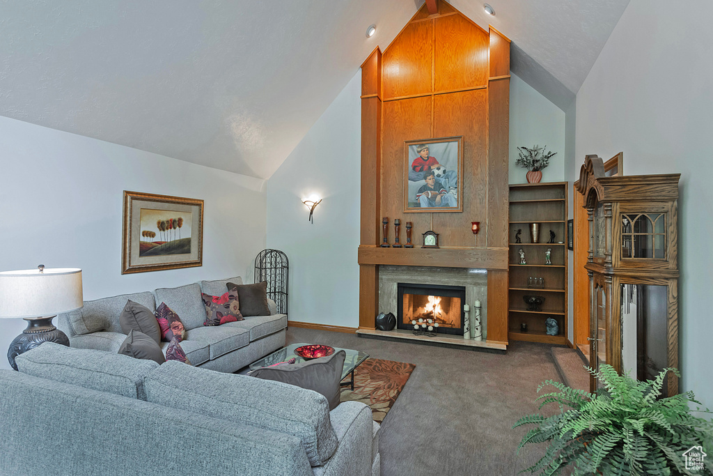 Living area featuring lofted ceiling, carpet, and a warm lit fireplace
