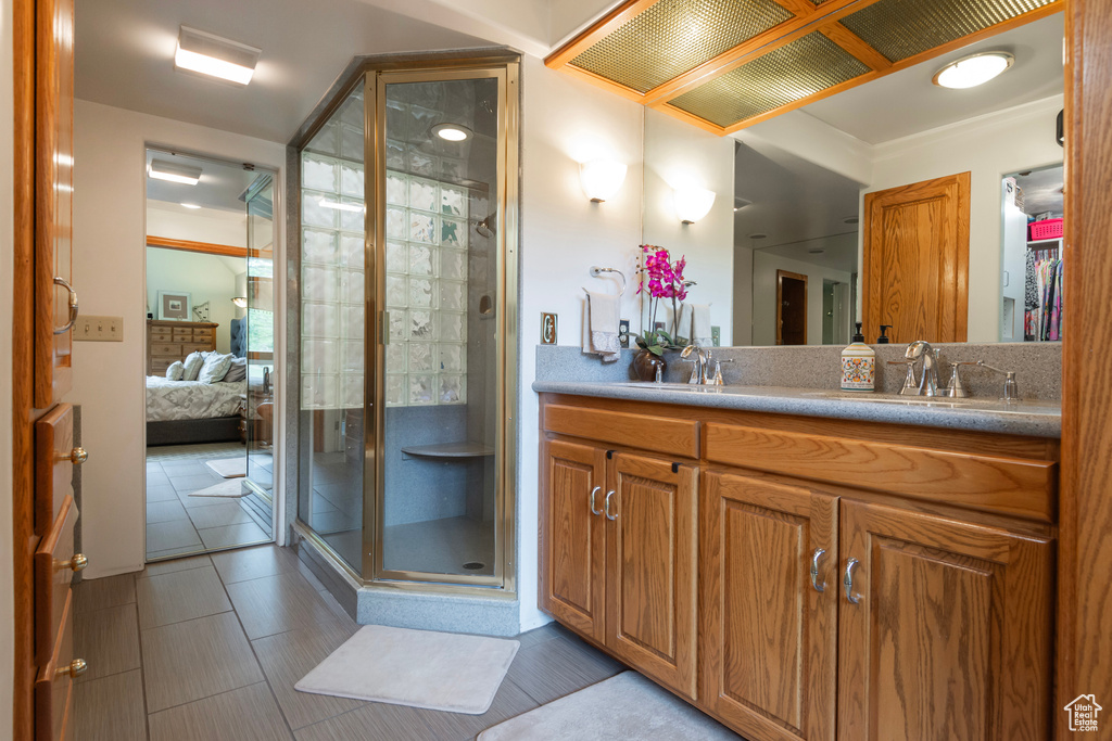 Ensuite bathroom with a shower stall, vanity, and tile patterned flooring