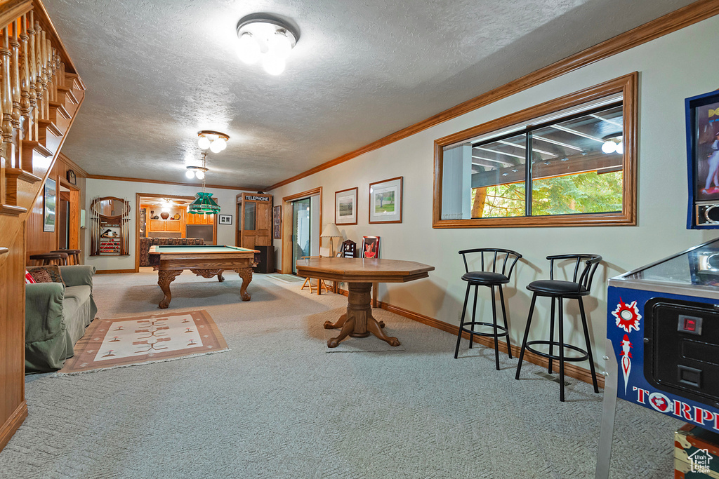 Game room with carpet floors, baseboards, crown molding, billiards, and a textured ceiling