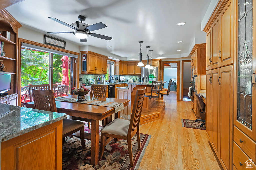 Dining area featuring light wood-type flooring, ceiling fan, and recessed lighting