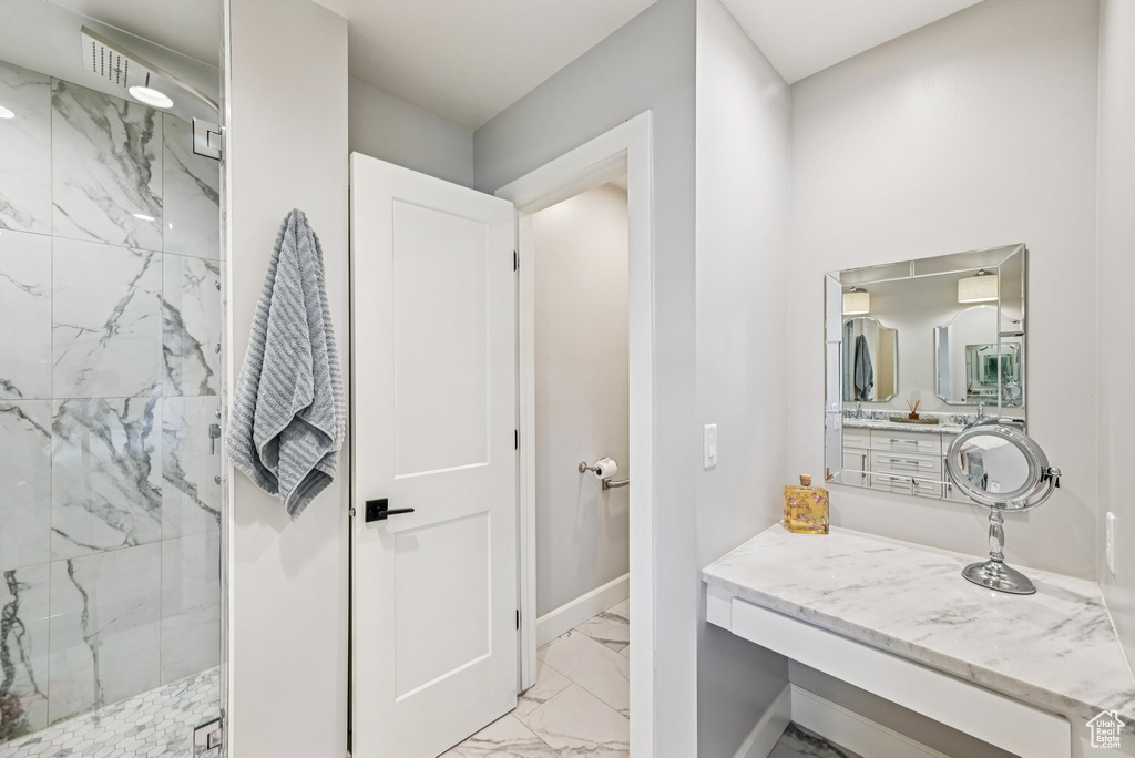 Full bath with marble finish flooring, a marble finish shower, baseboards, and vanity