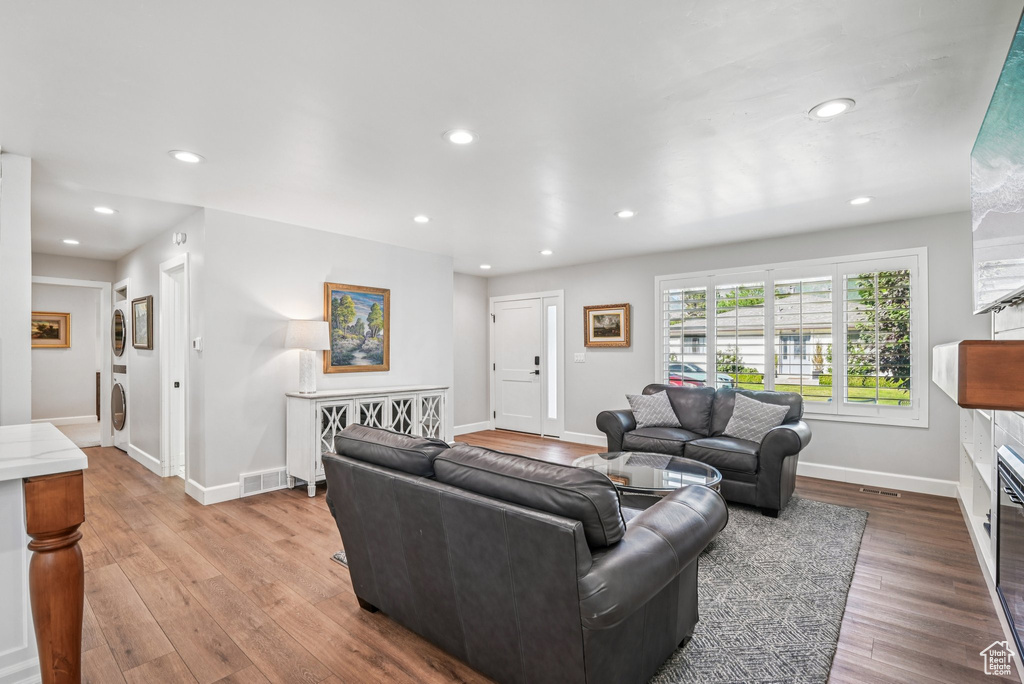 Living area featuring a glass covered fireplace, recessed lighting, wood finished floors, and baseboards