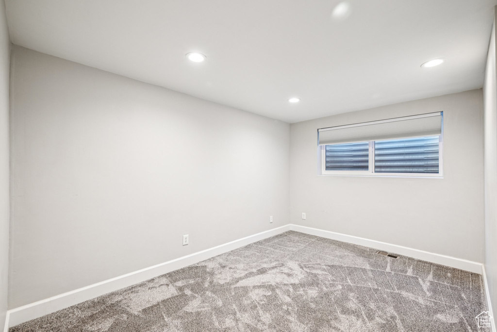 Carpeted empty room featuring baseboards and recessed lighting