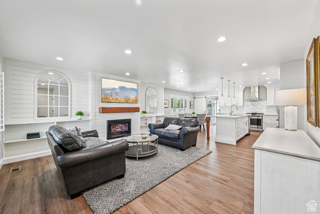 Living area with light wood-type flooring, recessed lighting, and a fireplace