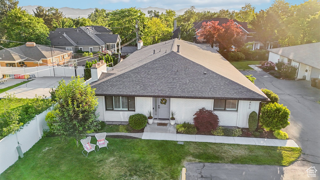 View of front of house featuring a shingled roof, brick siding, and a chimney