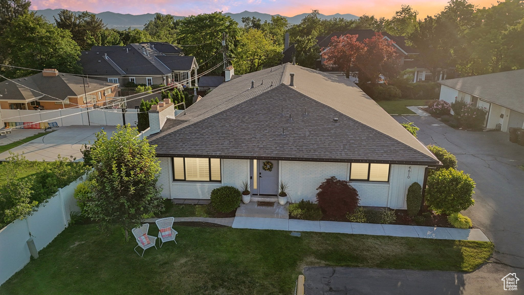 Single story home with roof with shingles, brick siding, and a chimney