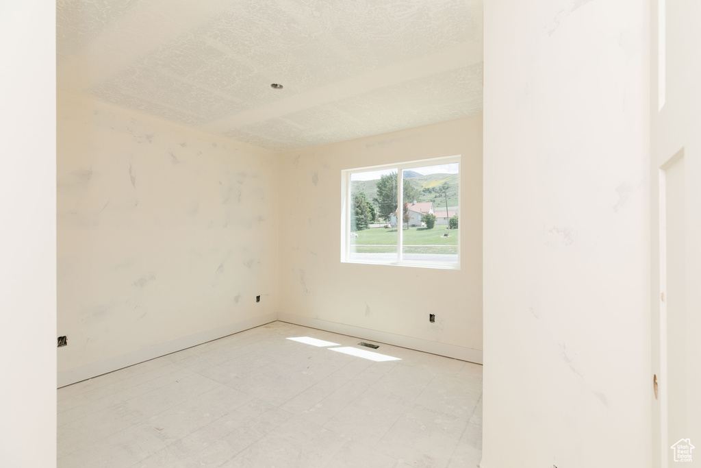Empty room featuring baseboards and light floors
