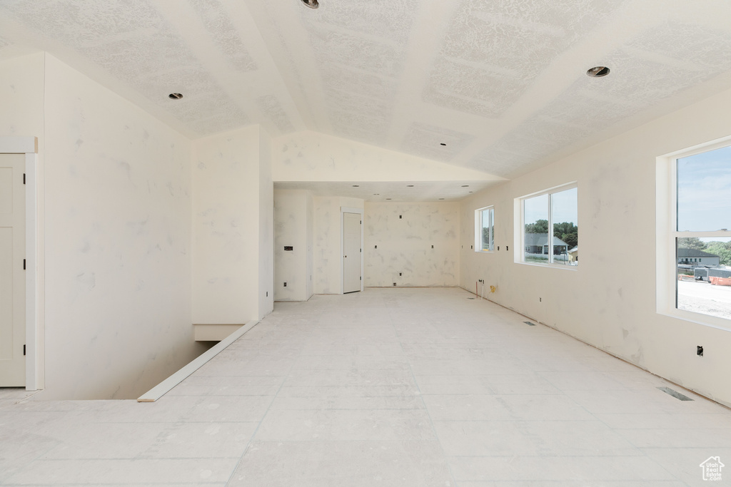 Empty room with lofted ceiling