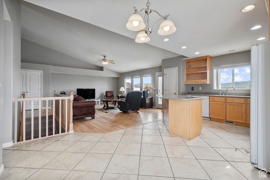 Kitchen featuring freestanding refrigerator, plenty of natural light, light tile patterned floors, recessed lighting, and vaulted ceiling