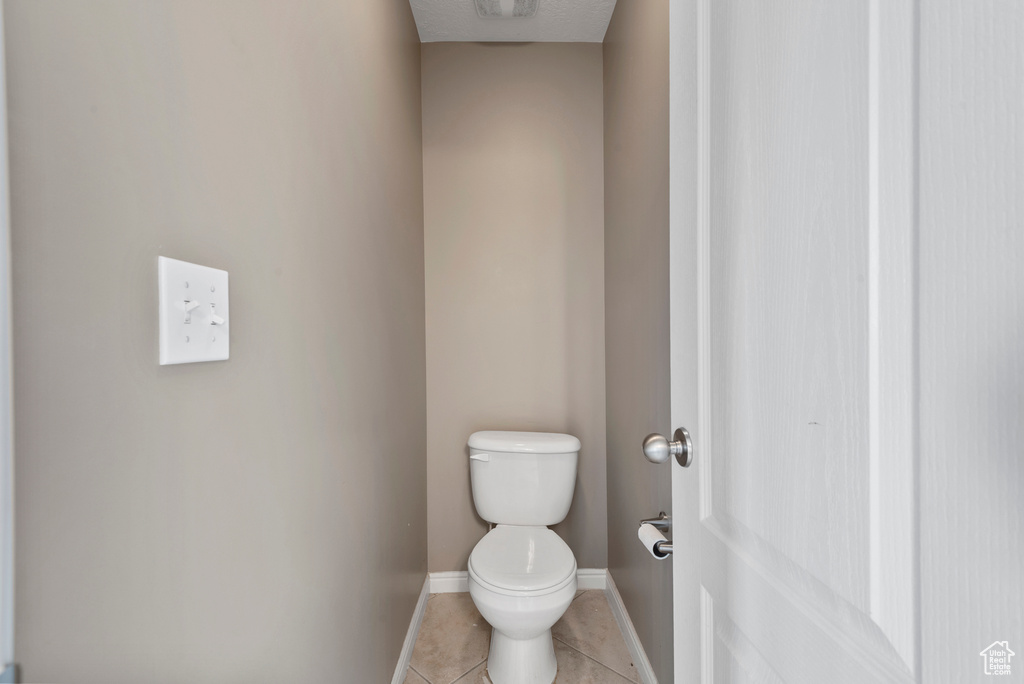 Bathroom with toilet and tile patterned flooring