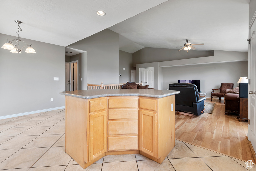 Kitchen with lofted ceiling, ceiling fan, a center island, light tile patterned flooring, and light brown cabinets