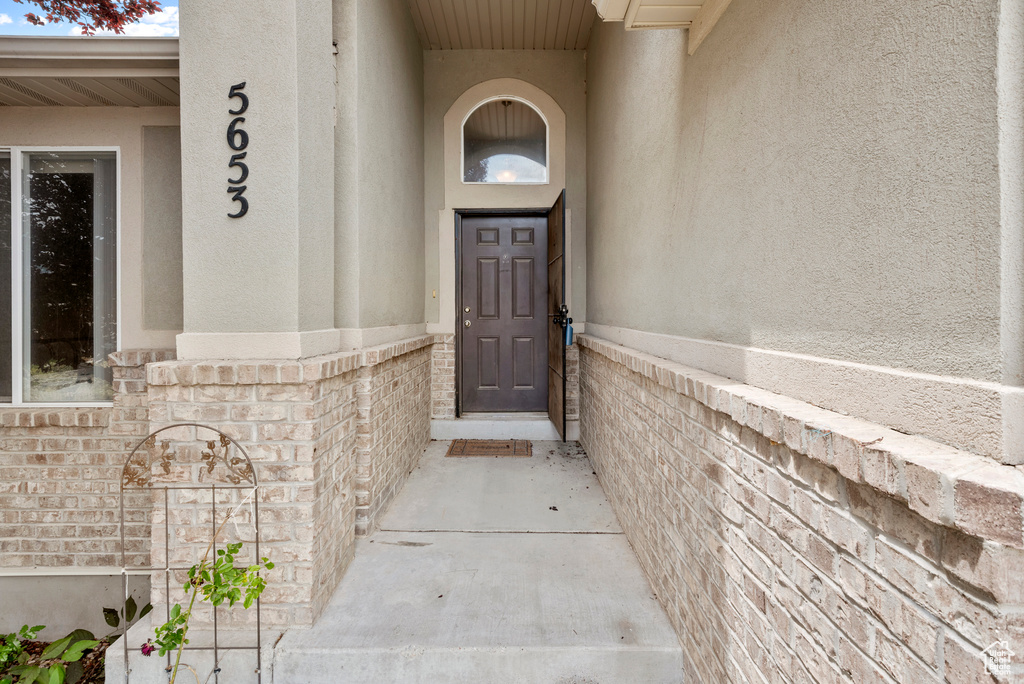Doorway to property featuring stucco siding
