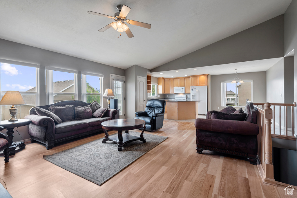 Living area featuring a ceiling fan, plenty of natural light, light wood-style flooring, recessed lighting, and high vaulted ceiling