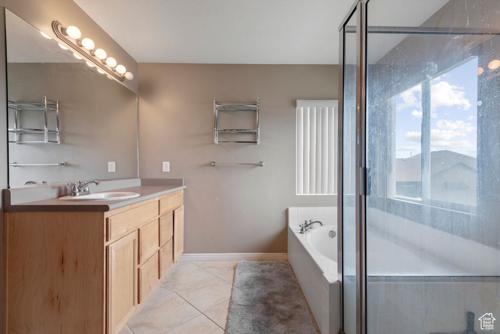 Full bathroom featuring vanity, tile patterned floors, a garden tub, and a stall shower