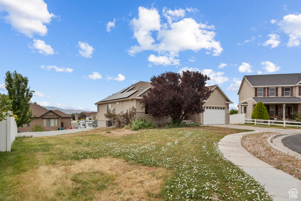 View of front of house with a residential view, a garage, driveway, and stucco siding