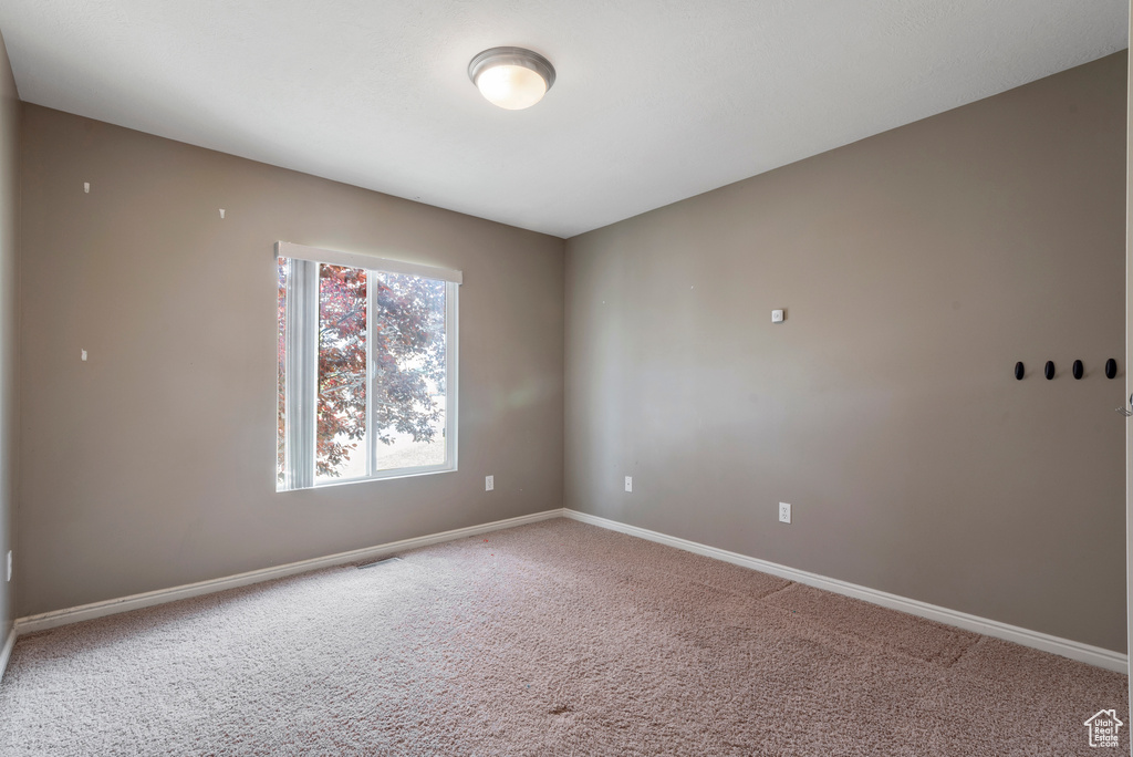 Spare room featuring carpet floors and baseboards