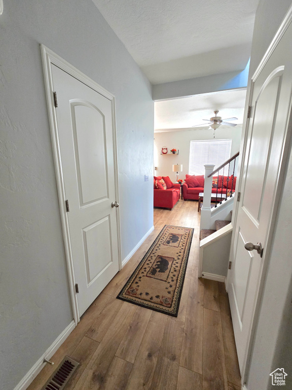 Hallway featuring hardwood / wood-style flooring and baseboards