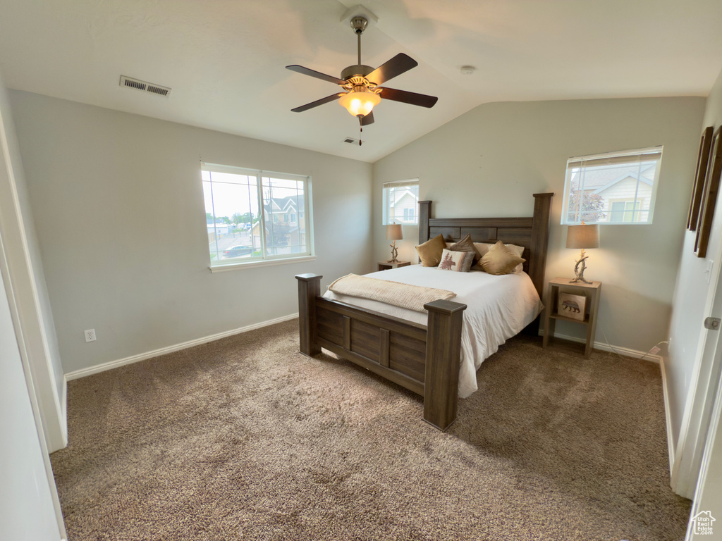 Carpeted bedroom featuring lofted ceiling and ceiling fan