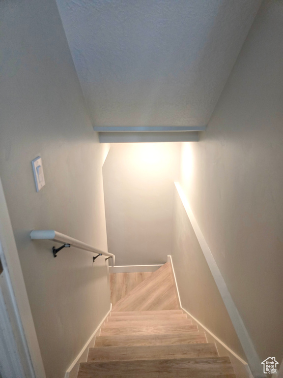 Staircase featuring wood finished floors and baseboards