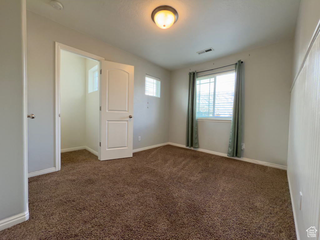 Carpeted spare room with baseboards and a smoke detector