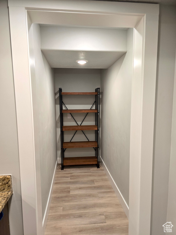 Hall with light wood-style flooring and baseboards