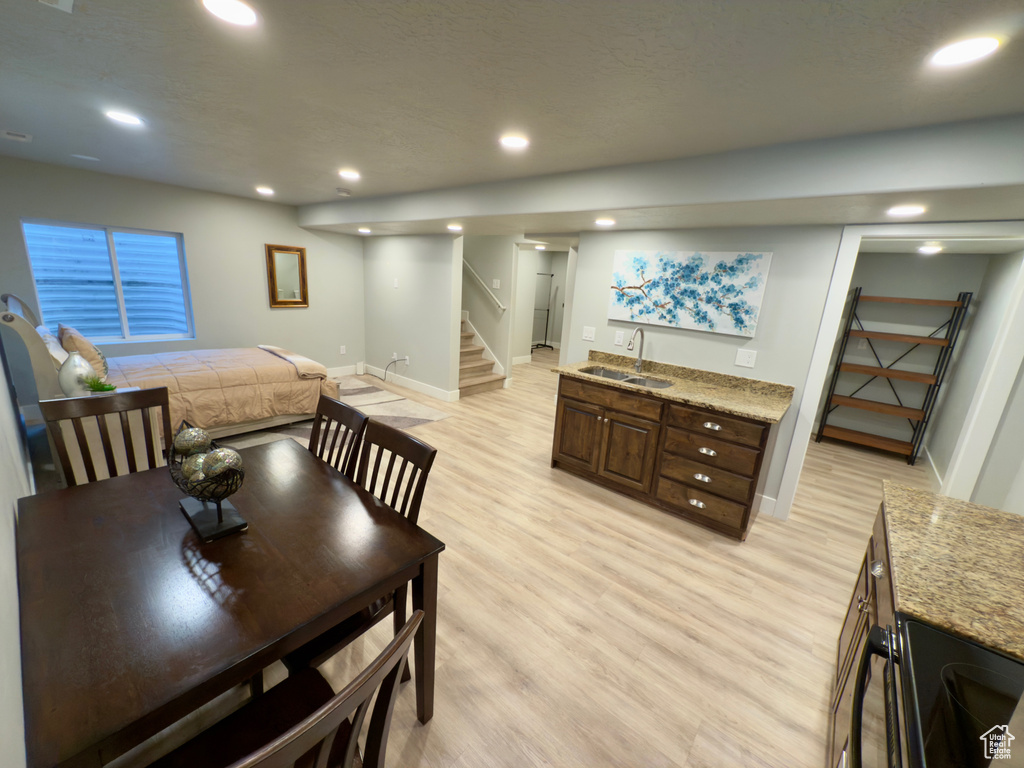 Dining room featuring light wood-type flooring, baseboards, stairs, and recessed lighting