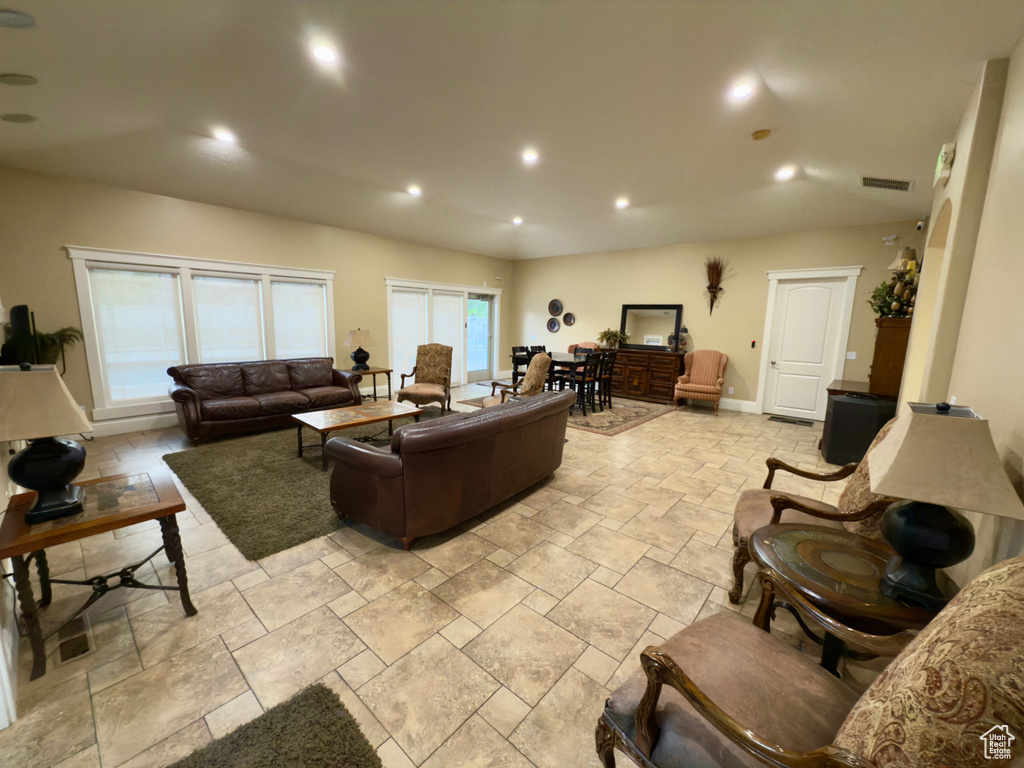 Living room featuring stone tile floors, recessed lighting, and baseboards