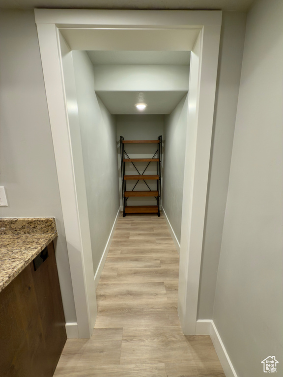 Hall with light wood-type flooring and baseboards