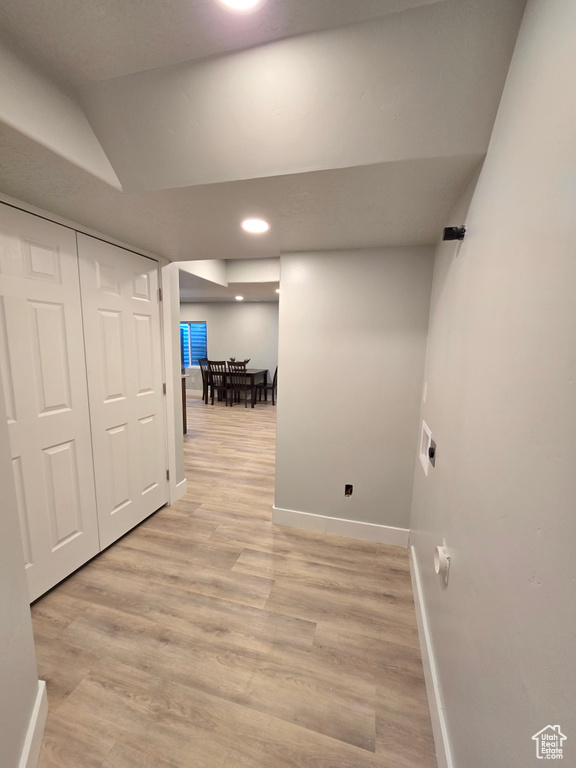 Corridor with baseboards, light wood-type flooring, vaulted ceiling, and recessed lighting