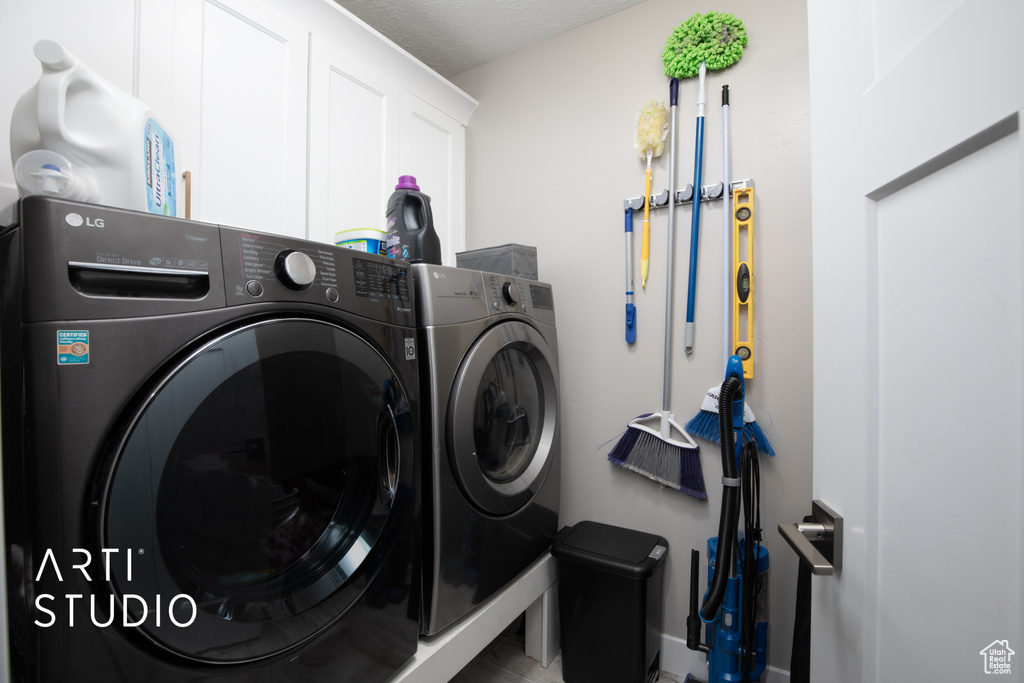 Laundry room featuring washing machine and dryer, cabinet space, and baseboards