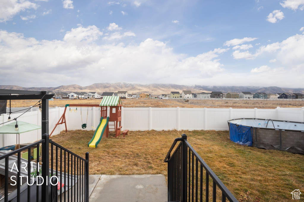 View of yard featuring a playground, a residential view, and a mountain view