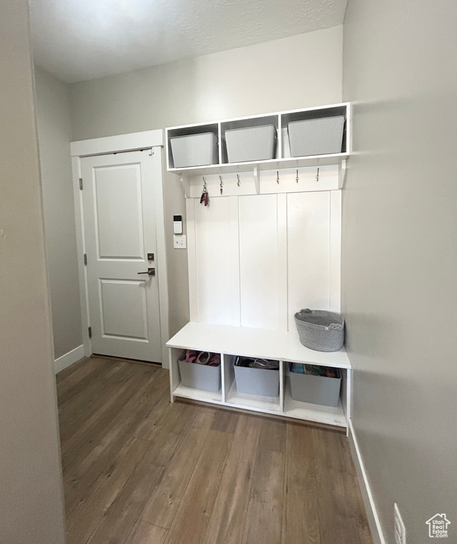 Mudroom featuring wood finished floors and baseboards