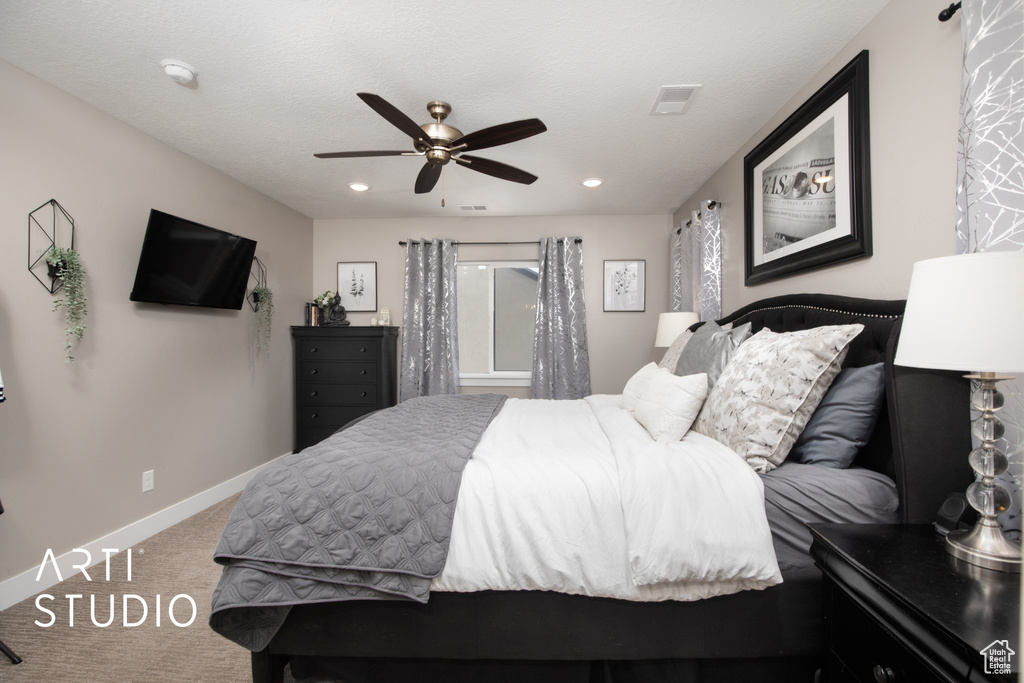 Carpeted bedroom featuring baseboards, ceiling fan, and recessed lighting